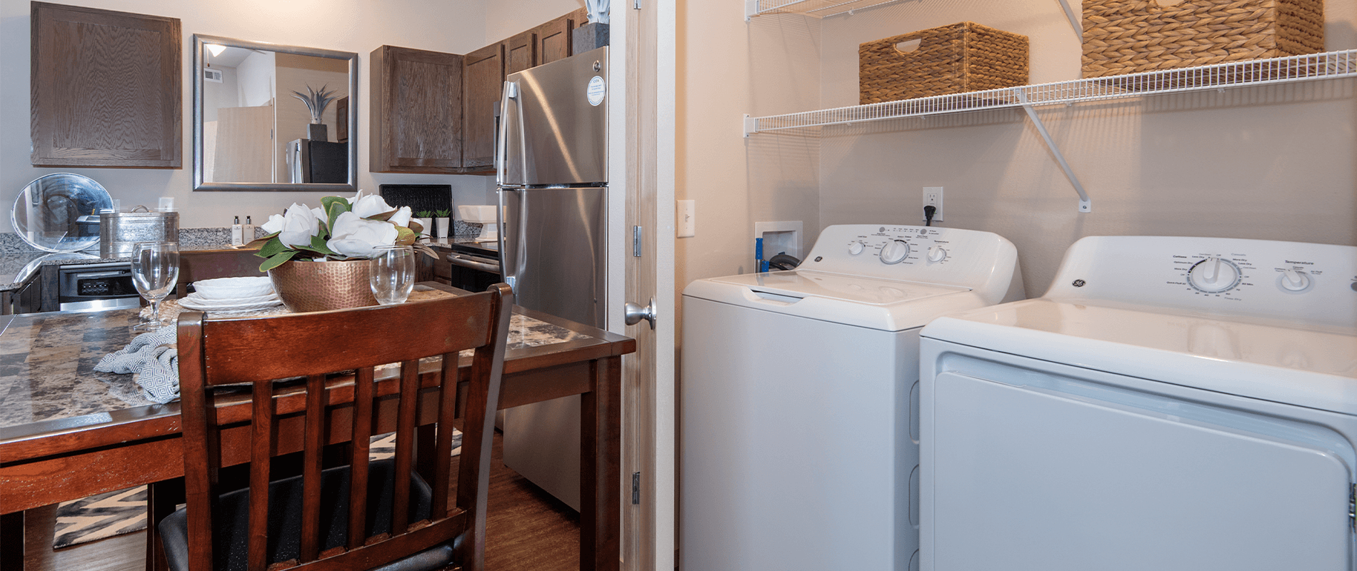 a kitchen with a washer and dryer and a table with a chair